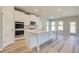 New kitchen has an island with white cabinets, stainless steel microwave, oven, and hardwood floors at 162 Haverling Pass, Hampton, GA 30252