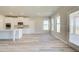 Modern kitchen with white cabinets, stainless steel appliances, and an open view to the dining and living rooms at 162 Haverling Pass, Hampton, GA 30252