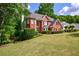 A well-maintained red brick home has a manicured lawn and mature landscaping at 265 Dogwood Walk Ln, Norcross, GA 30071
