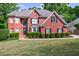 Charming two-story brick home featuring a well-manicured lawn and mature trees at 265 Dogwood Walk Ln, Norcross, GA 30071