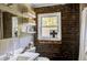 Rustic-style bathroom featuring exposed brick wall and shelves, complemented by modern fixtures at 3330 W Shadowlawn Ne Ave, Atlanta, GA 30305