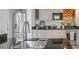 Well-lit kitchen featuring stainless steel appliances, white cabinets, granite countertops and exposed brick wall at 3330 W Shadowlawn Ne Ave, Atlanta, GA 30305