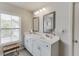 Bright bathroom featuring dual sinks, white cabinetry, and framed mirrors, illuminated by modern lighting at 4650 Silver Meadow Dr, Buford, GA 30519