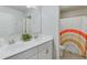 Clean bathroom with double sinks, rainbow shower curtain, and a door to another room at 4650 Silver Meadow Dr, Buford, GA 30519