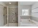 Modern bathroom featuring a glass-enclosed shower and a soaking tub with decorative tile accents at 4650 Silver Meadow Dr, Buford, GA 30519