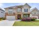 Charming two-story home with stone accents, a two-car garage, and lush landscaping enhancing curb appeal at 4650 Silver Meadow Dr, Buford, GA 30519