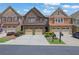 Brick townhome featuring an attached two-car garage, manicured landscaping, and a driveway perfect for multiple cars at 1929 Brightleaf Way, Marietta, GA 30060