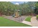 Community playground with slides, climbing structures, and benches surrounded by lush green grass and mature trees at 1929 Brightleaf Way, Marietta, GA 30060