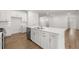 Stylish kitchen island featuring a stainless steel dishwasher, white cabinets and quartz countertops at 22 Foothills Trl, Sharpsburg, GA 30277