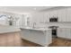 Modern kitchen featuring a large island, white cabinetry, stainless steel appliances, and hardwood floors at 22 Foothills Trl, Sharpsburg, GA 30277