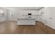 Bright, open kitchen with a large island, stainless steel appliances, white cabinets, and hardwood floors at 22 Foothills Trl, Sharpsburg, GA 30277