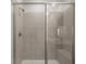 Contemporary walk-in shower featuring gray tiled walls, a built-in bench, and frameless glass door at 22 Foothills Trl, Sharpsburg, GA 30277