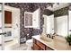 Floral-wallpapered bathroom featuring a sink, toilet, and access to a separate laundry room with washer and dryer at 320 Kirk Rd, Decatur, GA 30030