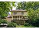 Back of house features a screened in porch, deck, second story windows, and lush landscaping at 320 Kirk Rd, Decatur, GA 30030