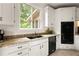Well-lit kitchen features granite countertops, black appliances, double sinks, and views of the backyard at 320 Kirk Rd, Decatur, GA 30030