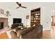 Spacious living room with hardwood floors, a brick fireplace, and a ceiling fan, with laundry room access at 320 Kirk Rd, Decatur, GA 30030