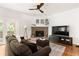 Cozy living room with a brick fireplace, a comfortable sofa, and a ceiling fan, offering a relaxing atmosphere at 320 Kirk Rd, Decatur, GA 30030