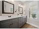 Bathroom features double sinks, quartz countertops, decorative mirrors and wood look floors at 8007 Wishaw Ct, Winston, GA 30187