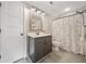 Well-lit bathroom with a modern vanity, stylish mirror, and a bathtub with a patterned shower curtain at 8007 Wishaw Ct, Winston, GA 30187