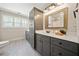Bathroom with a grey vanity, a large mirror, and a tub/shower combo at 8007 Wishaw Ct, Winston, GA 30187