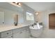 Elegant bathroom featuring double vanity, soaking tub, and natural light at 178 Haverling Pass, Hampton, GA 30228