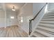 Bright entryway features wood-look flooring, wainscoting and staircase at 178 Haverling Pass, Hampton, GA 30228
