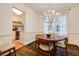 Charming dining area with round wood table, modern chandelier, and view into updated kitchen with stainless steel appliances at 2230 Peachtree Ne Rd # A-3, Atlanta, GA 30309