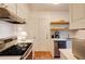 Efficient kitchen features stainless steel appliances, white cabinets, neutral countertops and tiled backsplash at 2230 Peachtree Ne Rd # A-3, Atlanta, GA 30309