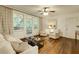 Spacious living room with hardwood floors, neutral furniture, and a view of the screened balcony at 2230 Peachtree Ne Rd # A-3, Atlanta, GA 30309