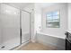 Bathroom with a glass door shower, soaking tub and a bright window at 3805 Alden Pl, Cumming, GA 30028