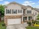 Charming two-story home featuring stone accents, a two-car garage, and a welcoming front porch at 3805 Alden Pl, Cumming, GA 30028