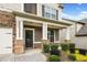 Inviting front porch with stone columns and manicured landscaping, a perfect entry to the home at 3805 Alden Pl, Cumming, GA 30028