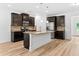 Well-lit kitchen features dark cabinetry, stainless steel appliances, granite counters, and a center island at 3805 Alden Pl, Cumming, GA 30028
