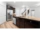 Kitchen island boasts a stainless fridge and sink overlooking a staircase to the second floor at 3805 Alden Pl, Cumming, GA 30028