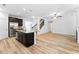 Open-concept living space featuring kitchen island, staircase, fireplace, and stainless appliances at 3805 Alden Pl, Cumming, GA 30028