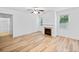 Bright living room featuring a decorative fireplace and large window, complemented by wood-look flooring at 3805 Alden Pl, Cumming, GA 30028