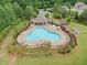 Community pool featuring unique design, ample seating, and adjacent green space at 3805 Alden Pl, Cumming, GA 30028