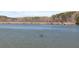 Calm lake featuring a small boat and a tree-lined shore under a blue sky at 3949 Fairhaven Rd, Lithia Springs, GA 30122