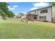 Large backyard with a well-maintained lawn, a covered patio, and a white fence at 565 Barsham Way, Johns Creek, GA 30097
