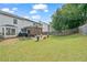 Spacious backyard featuring a covered patio, a well-maintained lawn, and a wooden fence at 565 Barsham Way, Johns Creek, GA 30097