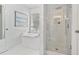 Bright primary bathroom featuring a soaking tub and glass-enclosed shower with white marble tiling at 565 Barsham Way, Johns Creek, GA 30097