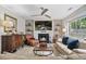 Living room featuring a fireplace, mantle, flat screen television and large picture window at 565 Barsham Way, Johns Creek, GA 30097