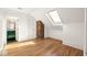 Bedroom with hardwood floors, skylight, and an entrance to the bathroom at 629 Hansell Se St, Atlanta, GA 30312