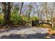 Gravel driveway and parking area surrounded by mature trees and a wooden fence at 629 Hansell Se St, Atlanta, GA 30312