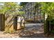 Gated entrance with wooden fences that open to reveal a gravel driveway and backyard space at 629 Hansell Se St, Atlanta, GA 30312