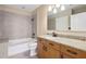 Bathroom featuring a tub shower combo, granite vanity top and wood cabinets at 950 W Peachtree Nw St # 1613, Atlanta, GA 30309