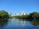Scenic view of the city skyline reflecting on a calm lake surrounded by lush trees at 950 W Peachtree Nw St # 1613, Atlanta, GA 30309