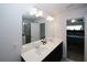 Bright bathroom featuring double sinks, a large mirror, and a view of the adjacent bedroom at 10162 Benton Woods Dr, Covington, GA 30014