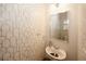 Stylish half-bath showcasing patterned wallpaper, a pedestal sink, and a modern mirror at 10162 Benton Woods Dr, Covington, GA 30014