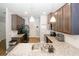 Well-lit kitchen with granite countertops, dark cabinets, and stainless steel appliances at 10162 Benton Woods Dr, Covington, GA 30014